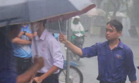 Tình nguyện viên dầm mưa hỗ trợ thí sinh
